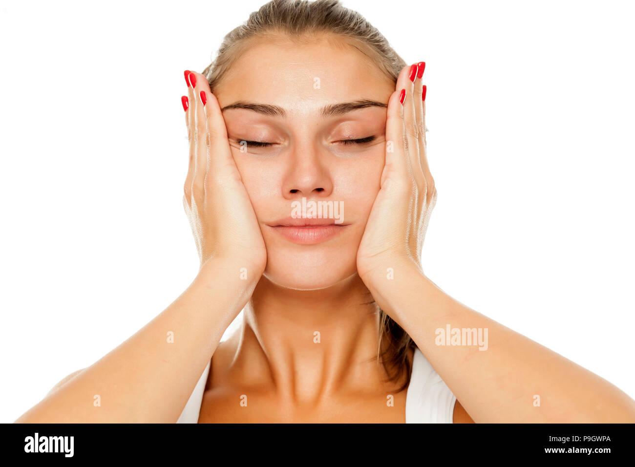 Jeune femme se resserre son visage avec ses mains Banque D'Images