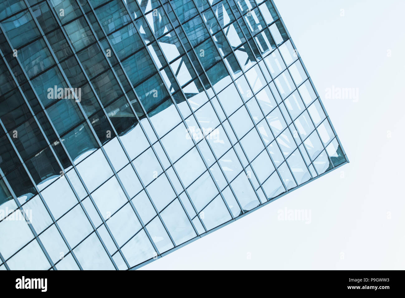 Résumé d'architecture moderne, fragment d'angle d'une tour à bureau en verre et acier under blue sky Banque D'Images