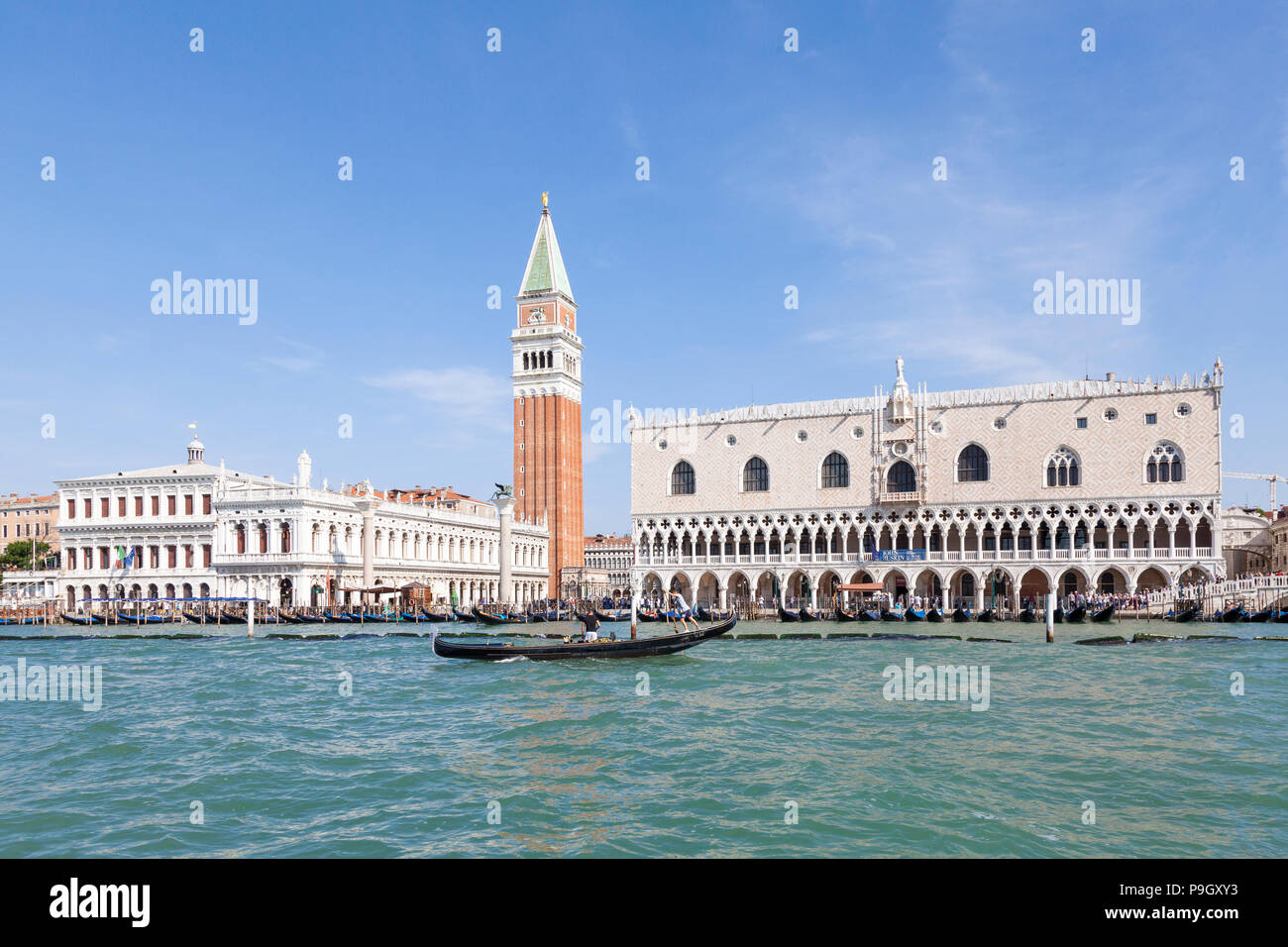 Le Palais des Doges et le Campanile St Marks, San Marco, Venise, Vénétie, Italie de Bacino San Marco avec une gondole passant par sur un ciel bleu ensoleillé jour Banque D'Images