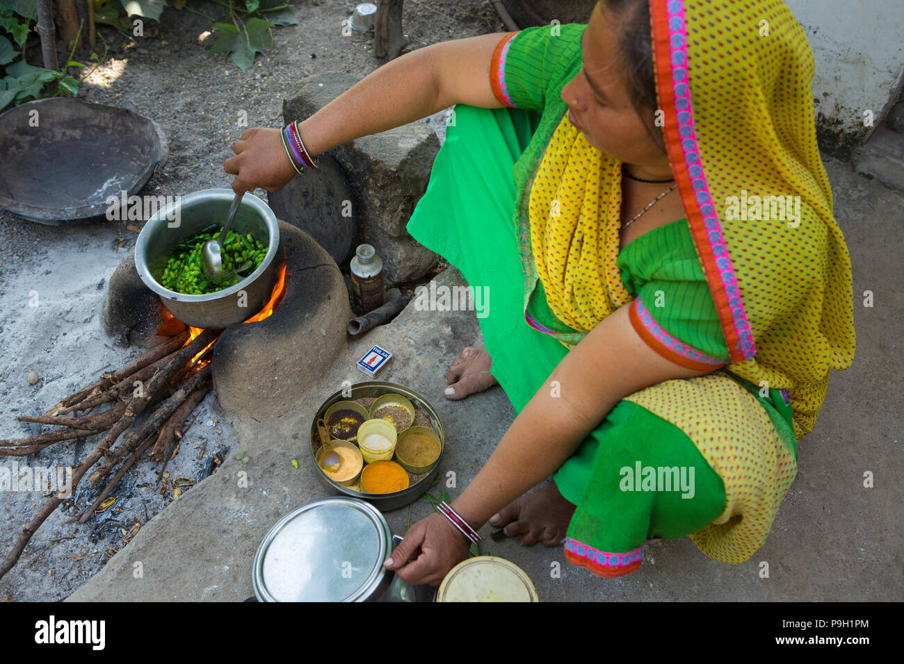 Une femme déjeuner dehors de cuisson sur un feu ouvert à leur domicile, à Ahmedabad, Inde. Banque D'Images