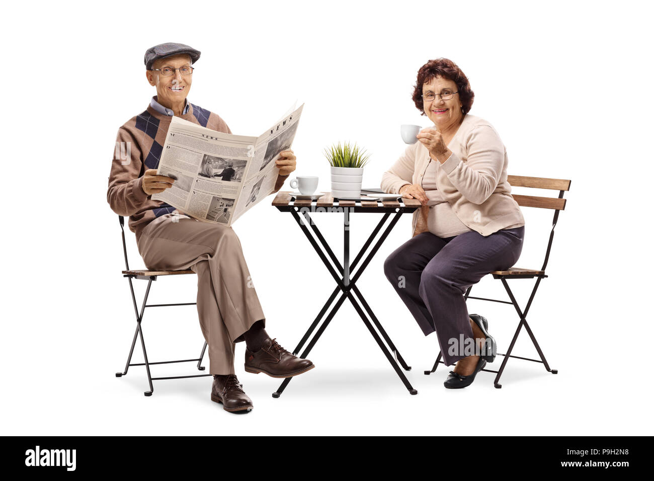 Homme âgé lire un journal assis à une table de café avec une femme âgée isolé sur fond blanc Banque D'Images