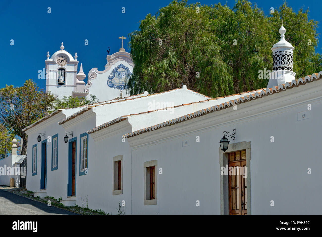 Une cheminée ouvragée et l'église de São Lourenço, Almancil, Algarve. Banque D'Images