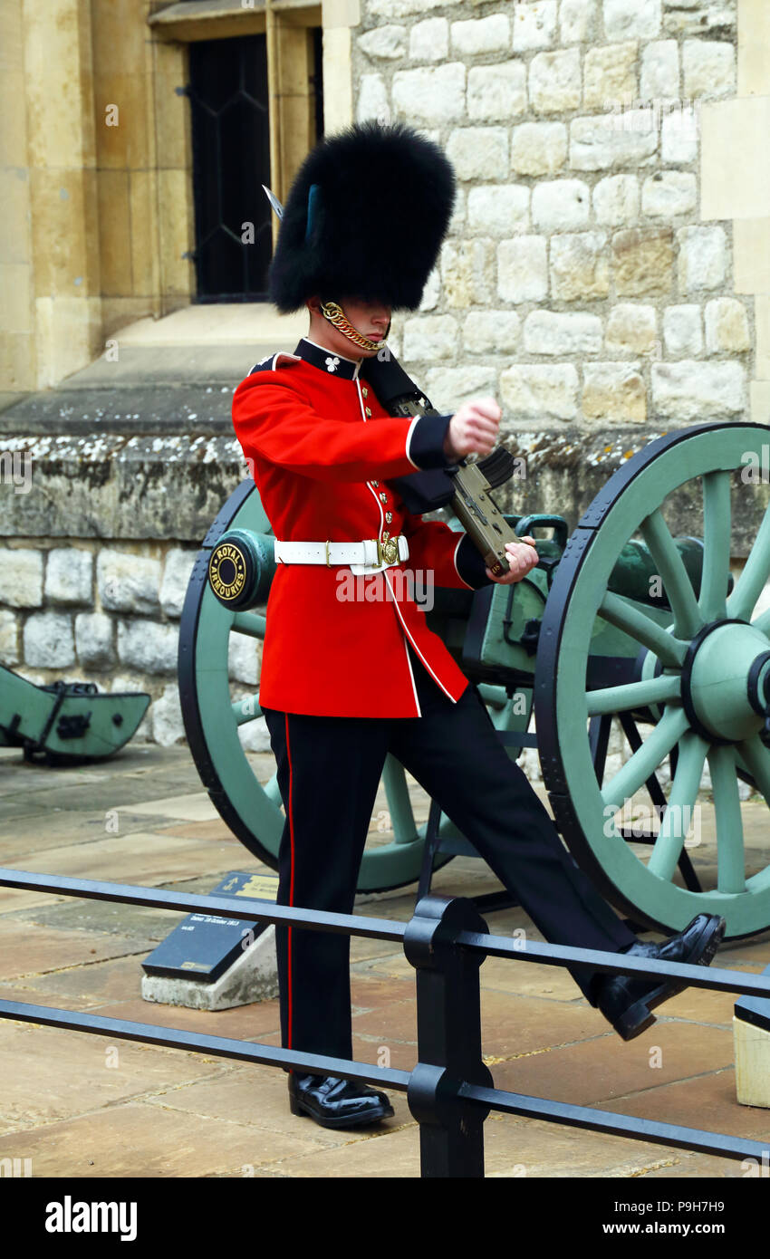 Un membre de la garde de la reine des marches et se distingue à la sentinelle de la Tour de Londres à Londres, en Angleterre. Banque D'Images