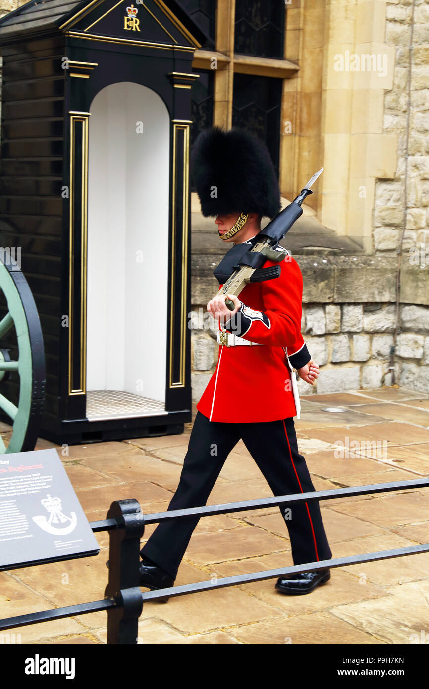 Un membre de la garde de la reine des marches et se distingue à la sentinelle de la Tour de Londres à Londres, en Angleterre. Banque D'Images