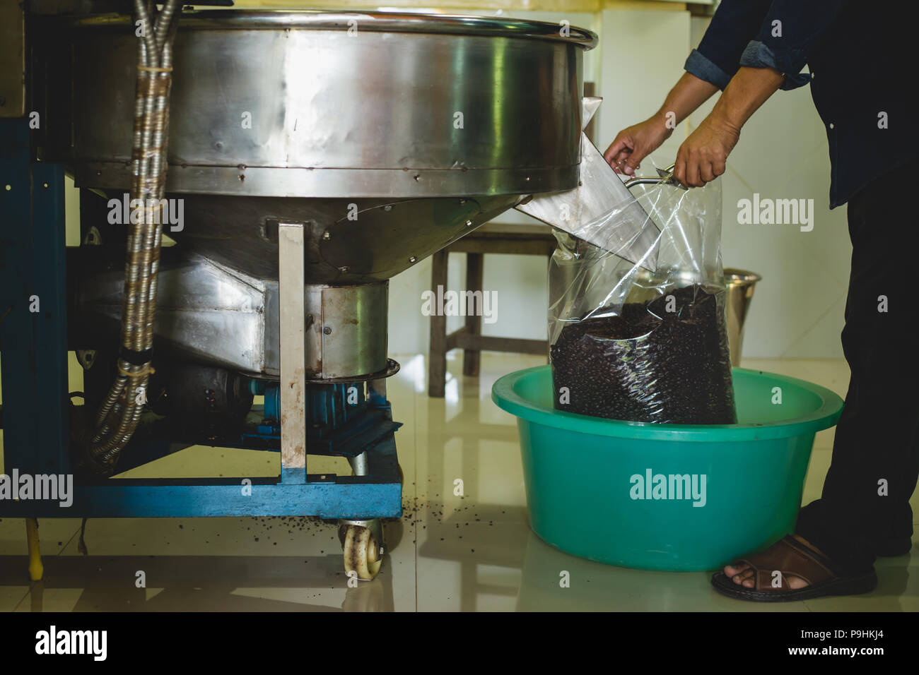 Verser les grains de café torréfiés dans le sac en plastique de la machine  torréfacteur pour vendre Photo Stock - Alamy
