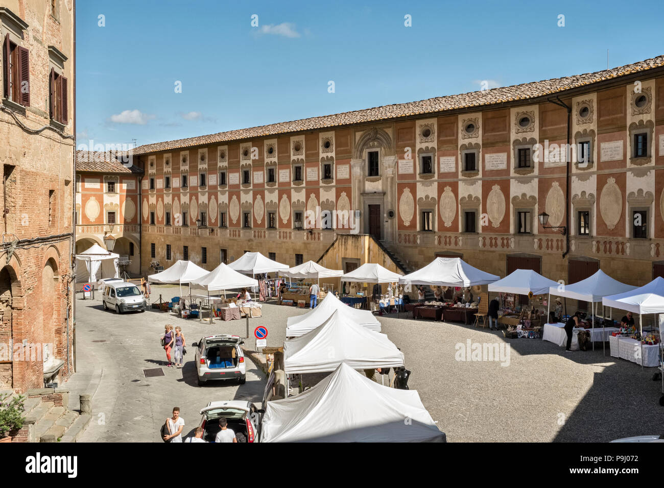 San Miniato, en Toscane, Italie. Les étals du marché de la Piazza della Repubblica, avec la façade de fresques du 18C Séminaire Épiscopal sur la droite Banque D'Images