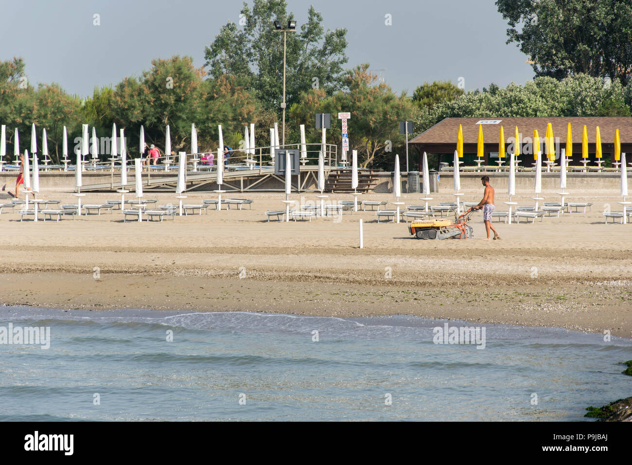 L'Europe, Italie, Vénétie, Caorle. Préparé pour les touristes à la plage Lido Altanea, Citta di Caorle. Hommes travaillant à la plage. Banque D'Images