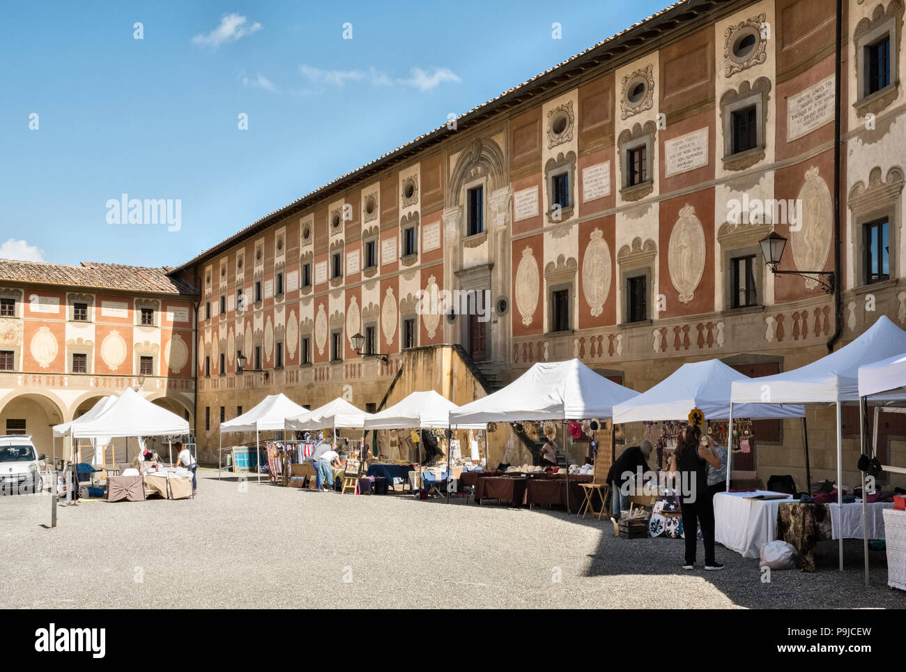 San Miniato, en Toscane, Italie. Les étals du marché de la Piazza della Repubblica, avec la façade de fresques du 18C Séminaire Épiscopal sur la droite Banque D'Images
