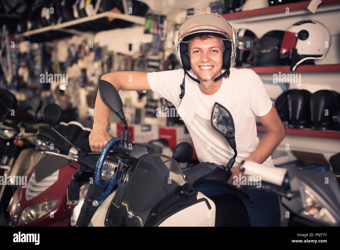 Portrait d'homme heureux français positif dans le casque de moto dans le  magasin Photo Stock - Alamy