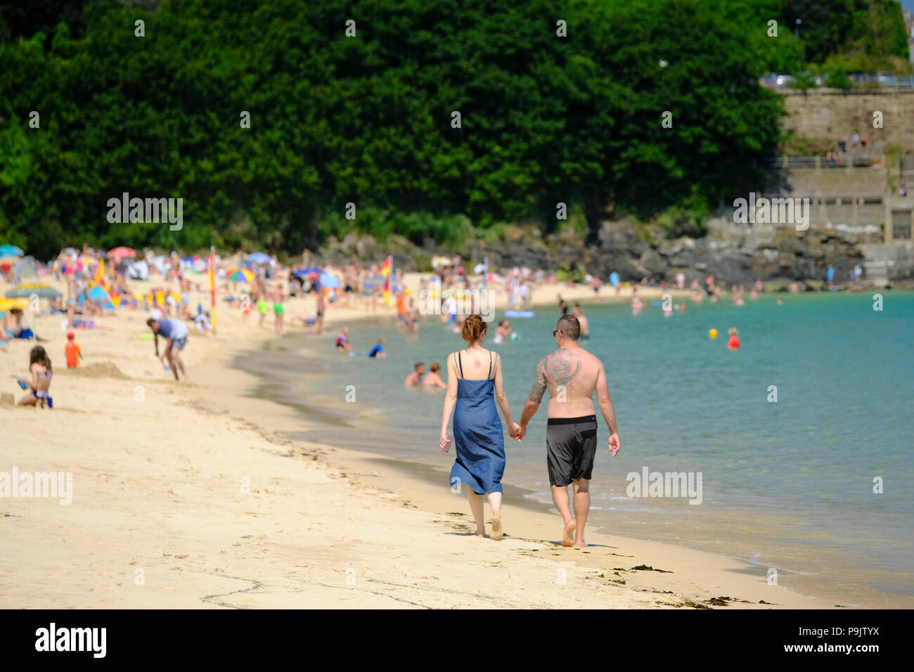 Couple d'âge moyen de marcher le long du rivage de la plage de Porthminster à St Ives Cornwall Banque D'Images