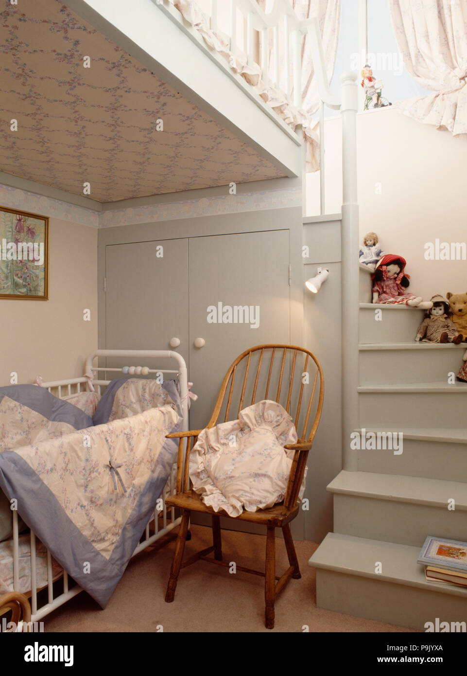 Windsor chaise à côté de blanc lit bébé dans la chambre de l'enfant avec  mezzanine à l'escalier en bois gris Photo Stock - Alamy