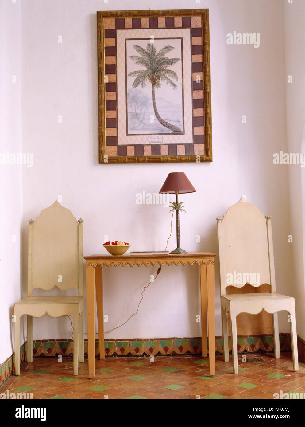 Photo de palmier au-dessus de la console simple table et chaises en bois  dans le hall avec sol marocain Photo Stock - Alamy