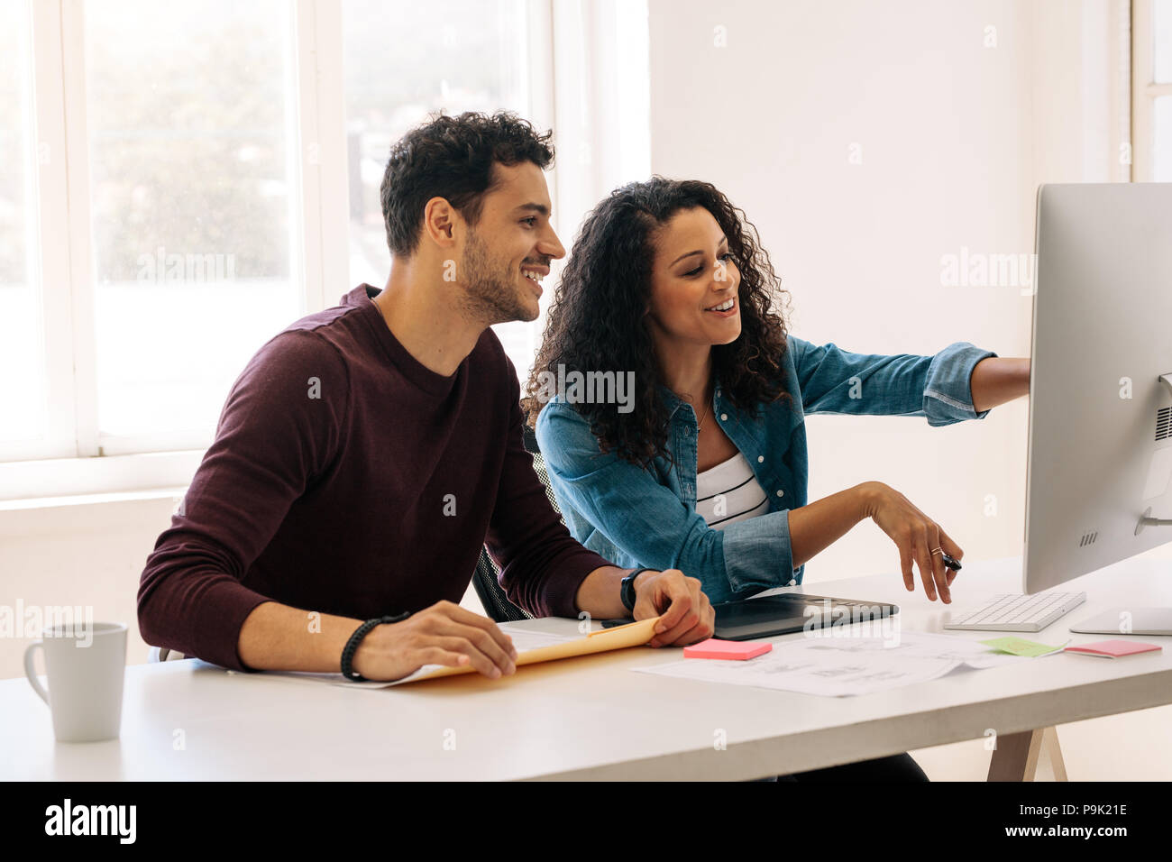 Businesswoman dirigée vers l'ordinateur avec un pavé numérique sur la table. Femme entrepreneur discuter travail avec assise à son collègue Banque D'Images