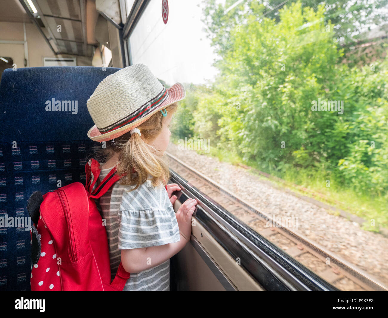 Jeune fillette de trois ans à la recherche d'une fenêtre de train, Londres, UK Banque D'Images
