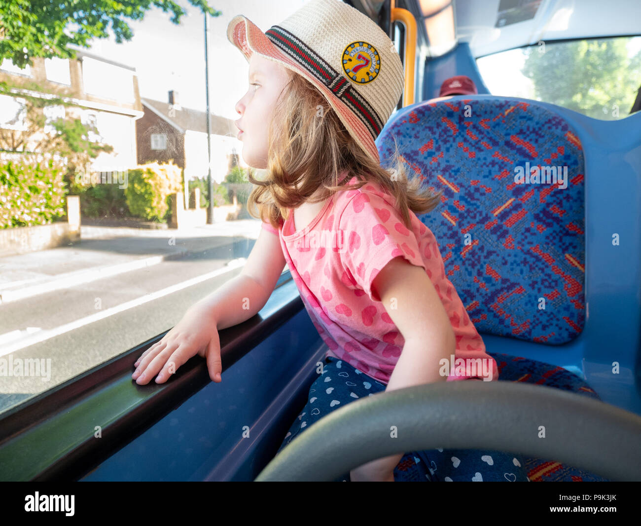 Jeune fillette de trois ans à la recherche d'une fenêtre de l'autobus, London, UK Banque D'Images