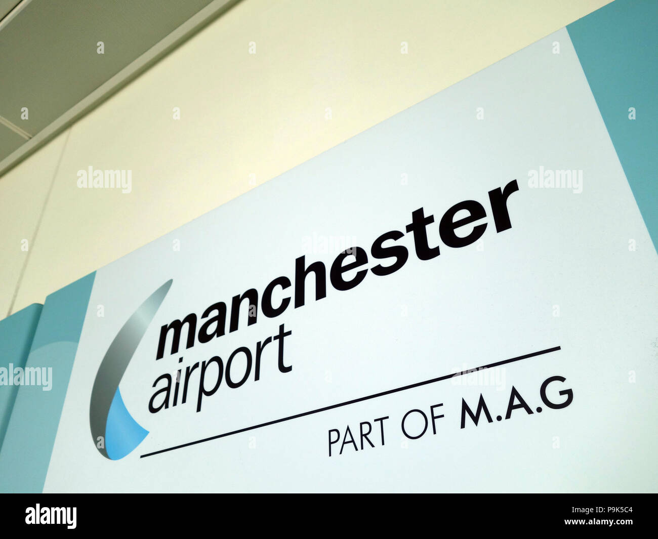 Les passagers devant la publicité sur les murs faisant leur façon de se connecter avec leur vol au Manchester Aéroports Terminal 3 Banque D'Images