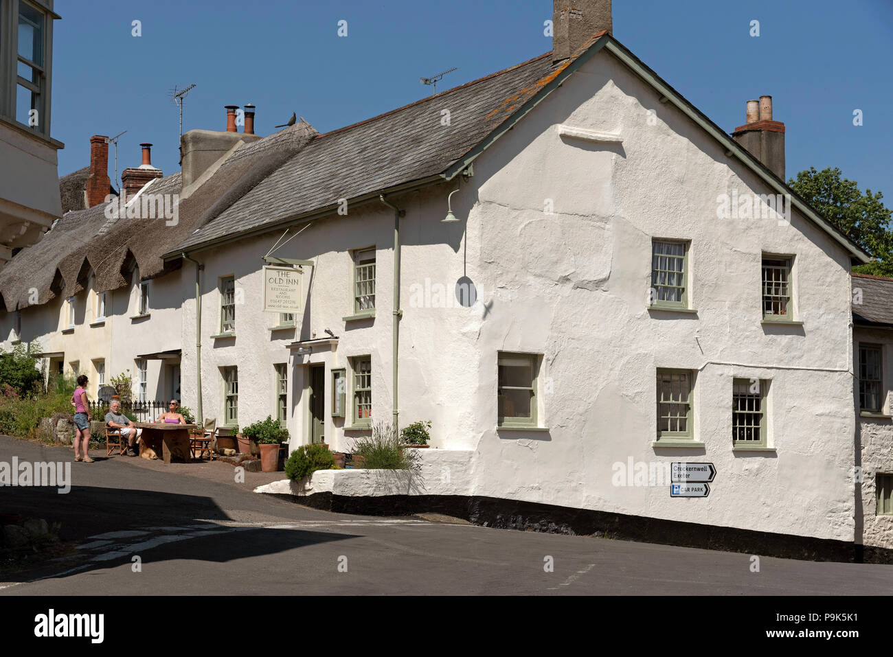 L'ancienne auberge dans Drewsteignto, Dartmoor National Park, Devon, Angleterre, Royaume-Uni. Chat de personnes sur le bord de la route Banque D'Images
