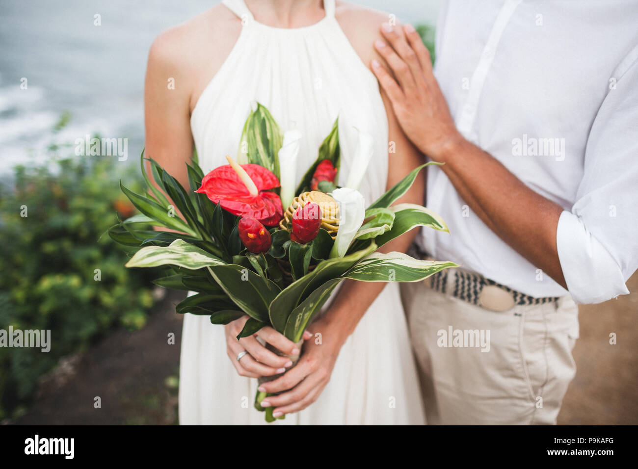 Rouge et vert avec bouquet de fleurs tropicales dans les mains de la mariée  Photo Stock - Alamy
