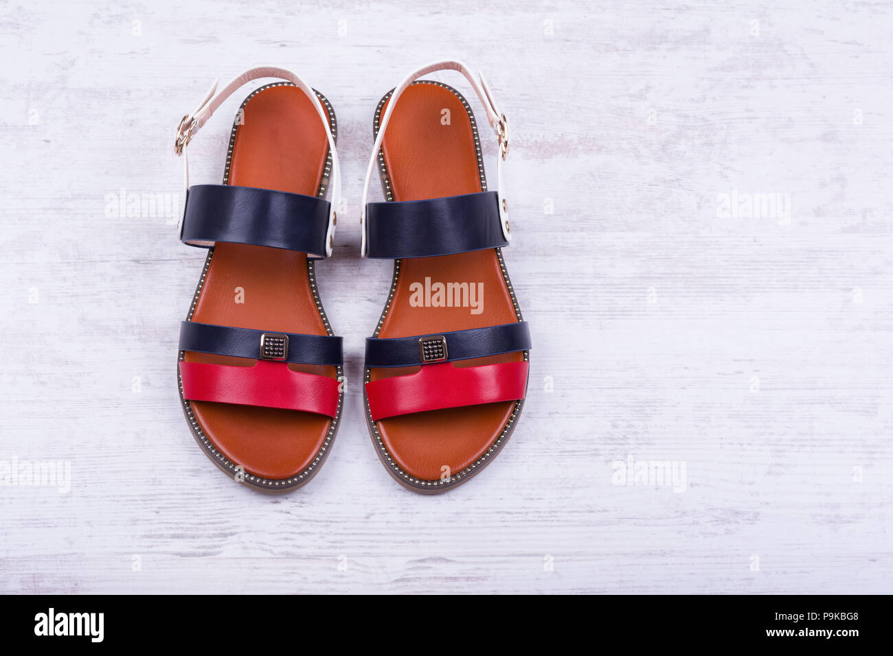Paire de sandales pour femmes à la mode sur fond de bois blanc. Banque D'Images