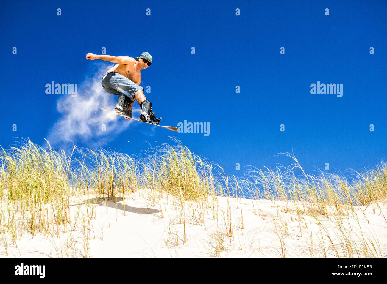 Sandboarder sautant sur les dunes de Ribanceira Beach. Imbituba, Santa Catarina, Brésil. Banque D'Images