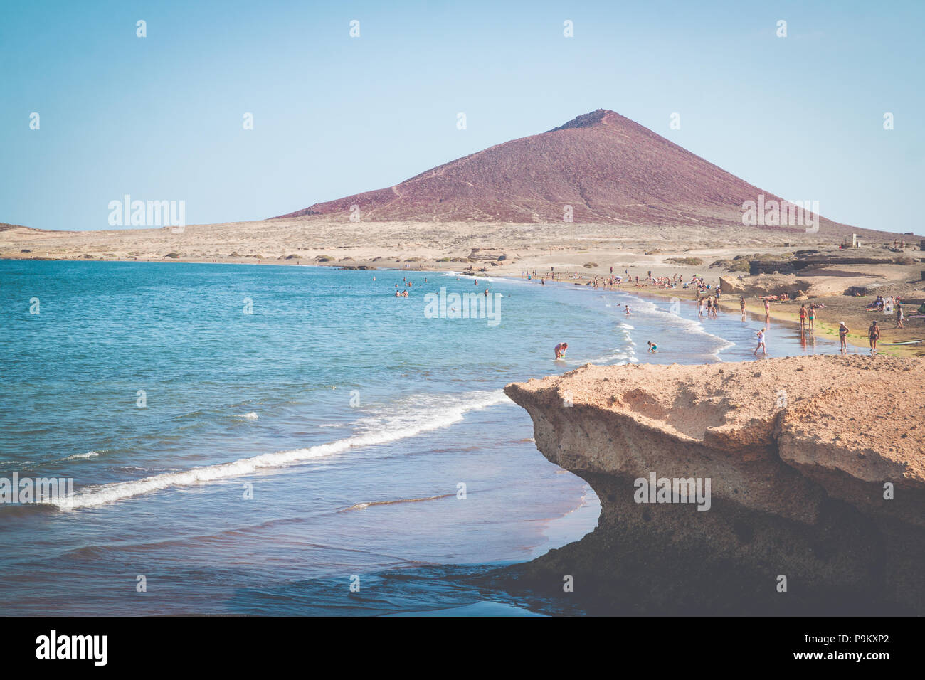 Playa El Médano beach et bay avec les touristes, l'océan Atlantique et la Montagne Rouge (La Montaña Roja) à Tenerife - Côte Sud Banque D'Images