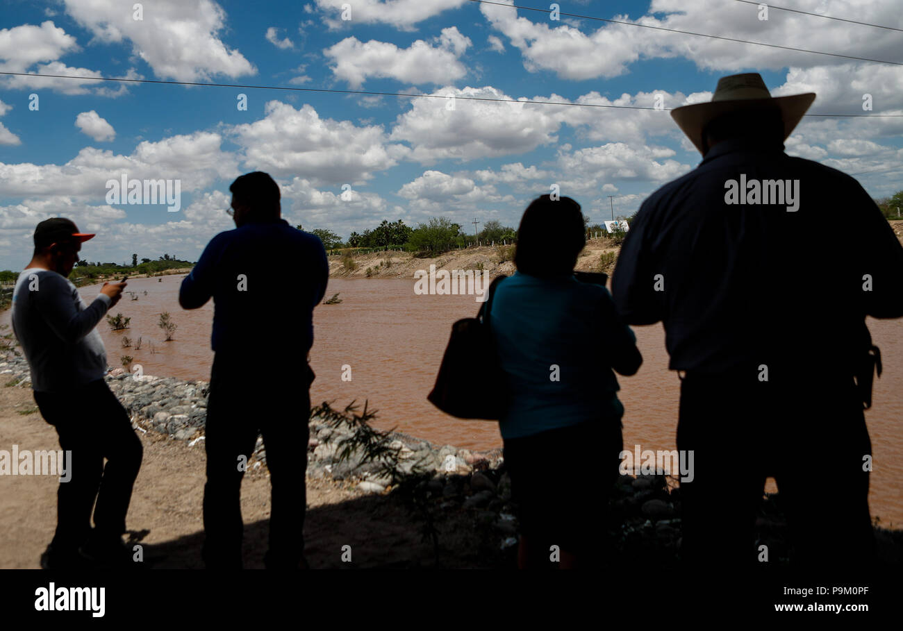 El Saucito, au Mexique. 18 juillet, 2018. Hermosillonses observer le canal d'eau de ce matin dans la rivière San Miguel. Débit d'eau de pluie dans le San Miguel River en passant par San Pedro El Saucito. Jet de l'eau qui coule dans l'Abelardo L. Rodr guez'barrage. Le courant d'eau a été généré à partir de la précipitation qui s'est produit dans la Sierra de Sonora. Credit : NortePhoto.com/Alamy Live News Banque D'Images