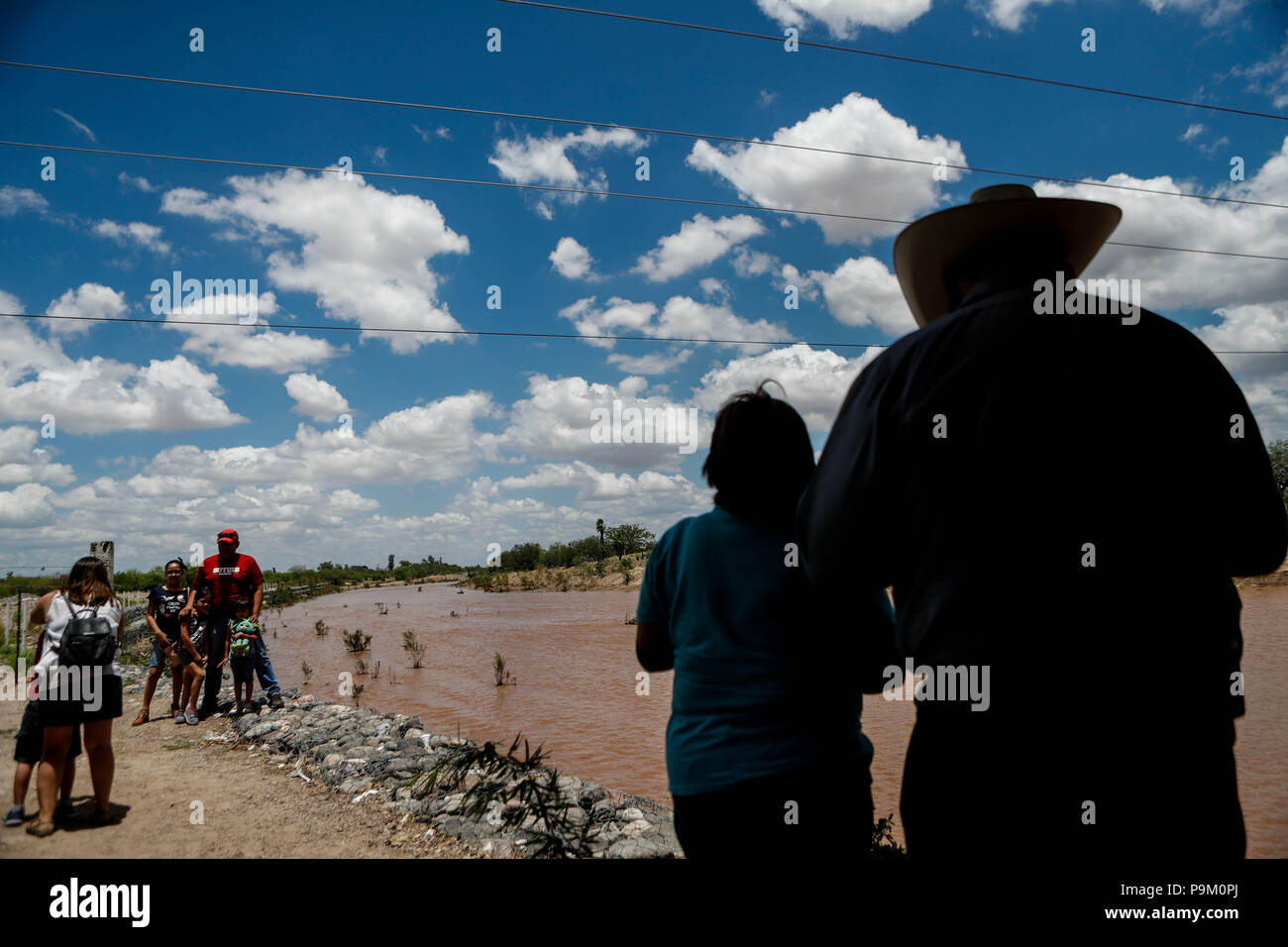 El Saucito, au Mexique. 18 juillet, 2018. Hermosillonses observer le canal d'eau de ce matin dans la rivière San Miguel. Débit d'eau de pluie dans le San Miguel River en passant par San Pedro El Saucito. Jet de l'eau qui coule dans l'Abelardo L. Rodr guez'barrage. Le courant d'eau a été généré à partir de la précipitation qui s'est produit dans la Sierra de Sonora. Credit : NortePhoto.com/Alamy Live News Banque D'Images