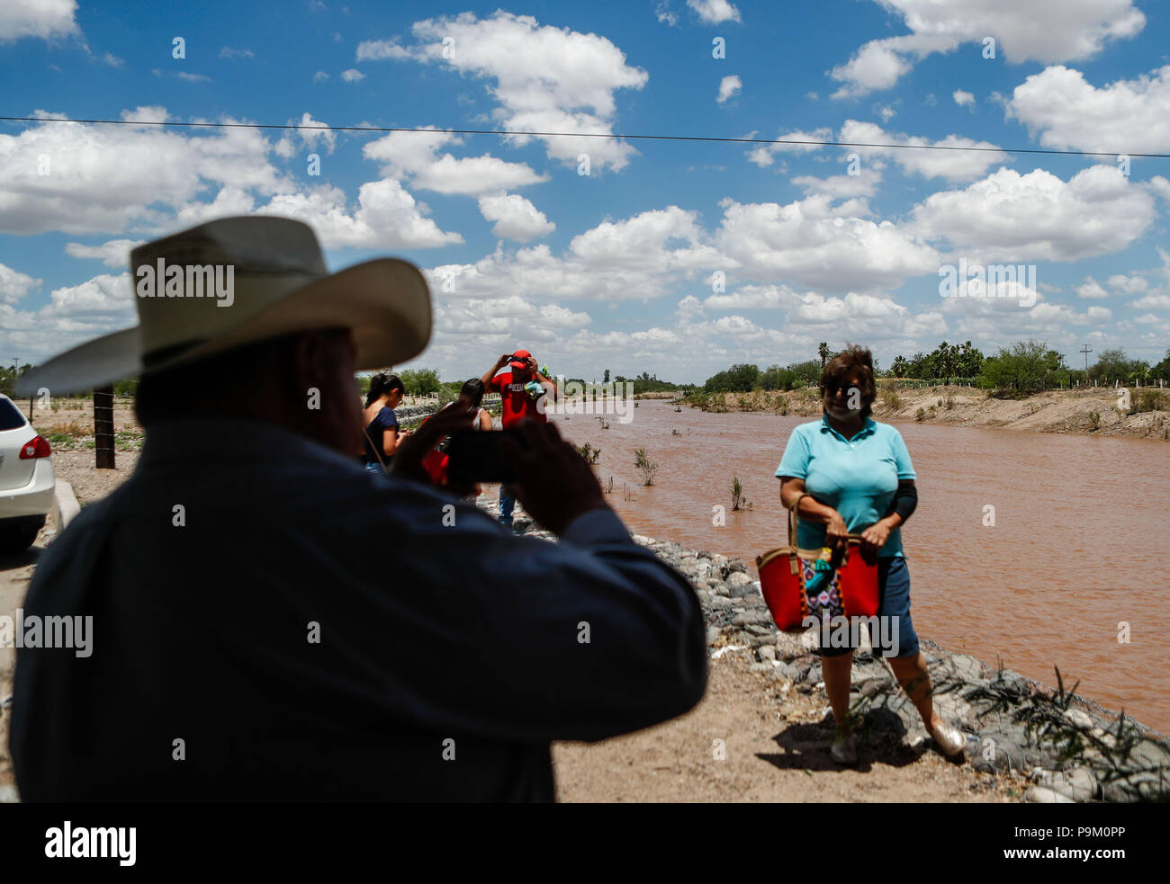 El Saucito, au Mexique. 18 juillet, 2018. Hermosillonses observer le canal d'eau de ce matin dans la rivière San Miguel. Débit d'eau de pluie dans le San Miguel River en passant par San Pedro El Saucito. Jet de l'eau qui coule dans l'Abelardo L. Rodr guez'barrage. Le courant d'eau a été généré à partir de la précipitation qui s'est produit dans la Sierra de Sonora. Credit : NortePhoto.com/Alamy Live News Banque D'Images