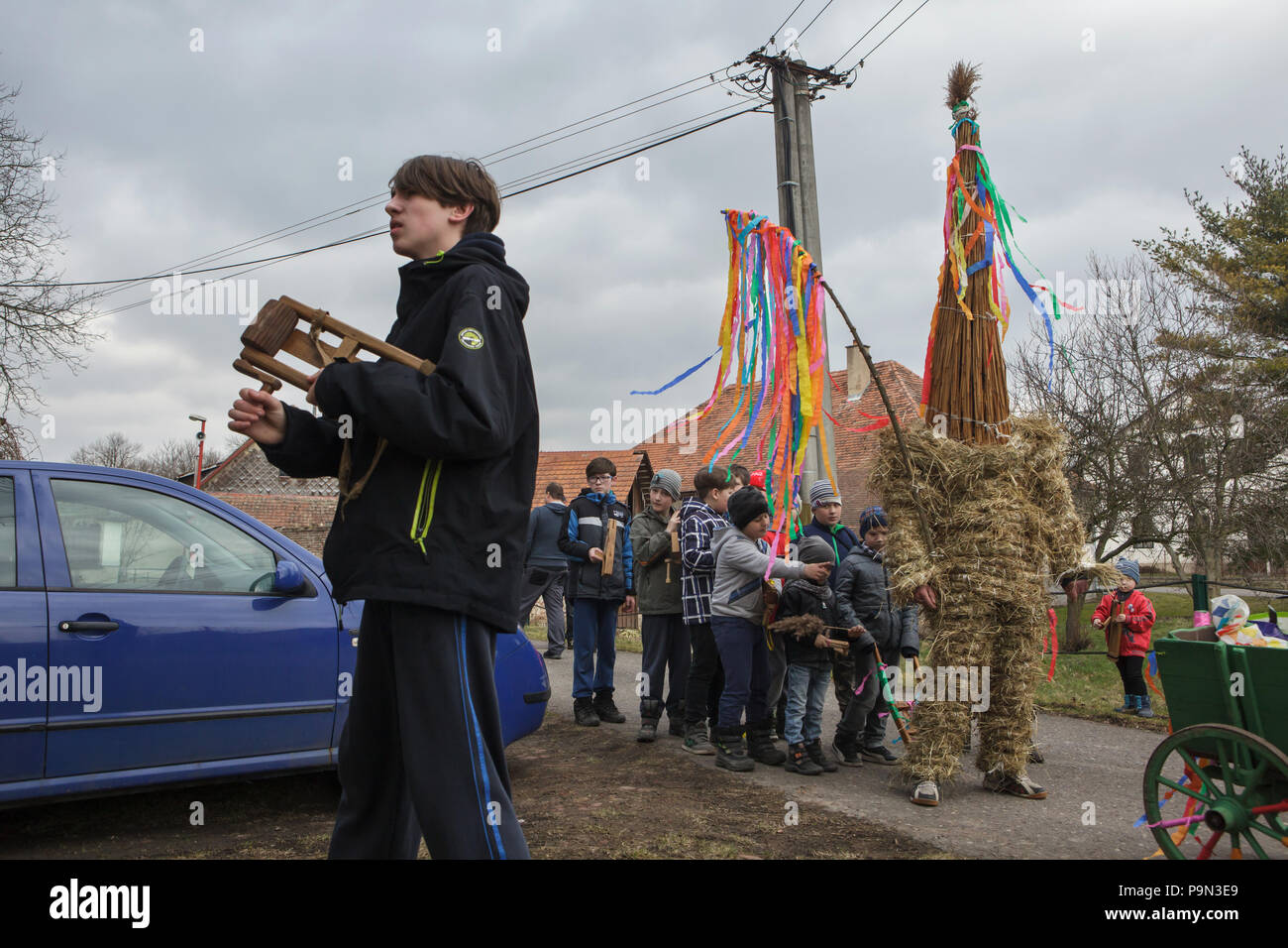 Procession de Pâques traditionnel connu comme Vodění Jidáše Judas (Marche) dans le village de Stradouň dans Pardubice, République tchèque. Une personne vêtue d'un costume de paille représentant Judas s'arrête en face d'une maison tandis que d'autres garçons en torsion et cliquets chanter pendant la procession, le 31 mars 2018. Tôt le matin le samedi saint, l'aîné adolescent dans le village est vêtu d'un ridicule costume de paille. Il est censé effectuer Judas Iscariot de cette façon. Le port de cette tenue obscure, il a mars dans le village de maison en maison escorté par d'autres garçons, qui tournez à cliquet en bois Banque D'Images
