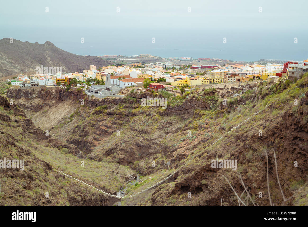 Paysage des Canaries à Ténérife. La ville d'Adeje de maisons construites au cours de la vallée escarpée de Barranco del Infierno en face de l'océan Atlantique. Aussi Banque D'Images