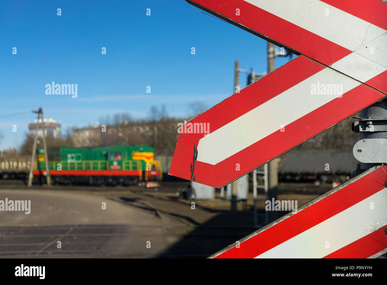 Signes d'avertissement à un passage à niveau avec un train diesel et de ciel bleu. Riga, Lettonie Banque D'Images