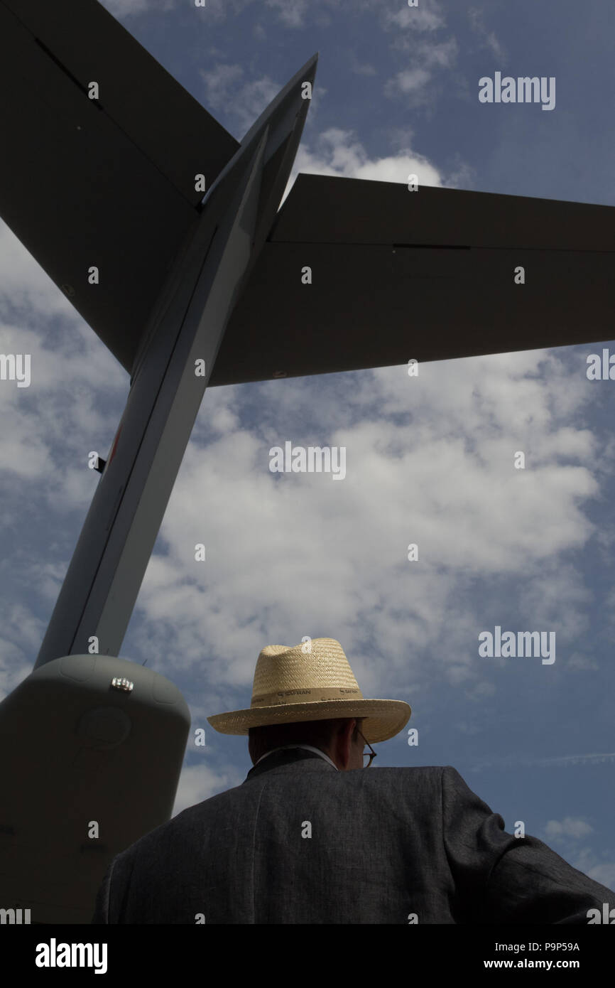 Un homme portant un chapeau se tient derrière l'avion de transport Airbus A400 tout en visitant le 50e Salon de l'aéronautique à l'aéroport du Bourget, France Banque D'Images