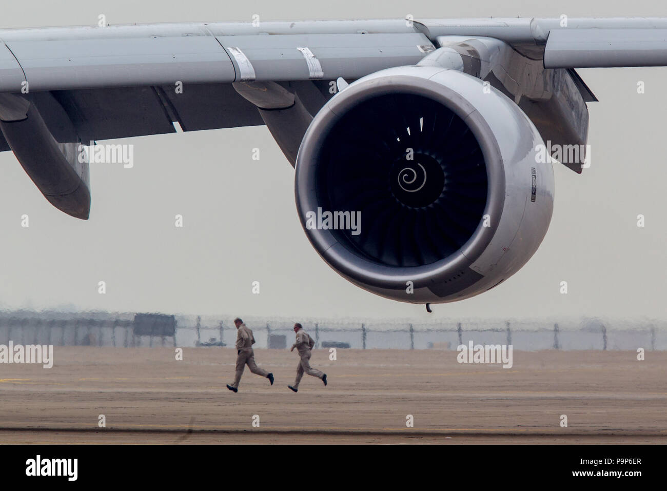 Deux hommes courent derrière le moteur Rolls-Royce Trent 900 à l'Airshow China 2014 à Zhuhai, Chine Banque D'Images