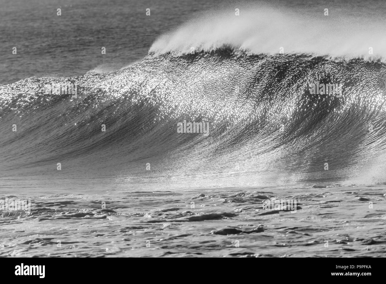 Océan vagues soleil brillant noir et blanc réflexions sur l'eau s'écraser d'épaisseur de la lèvre vers l'alimentation nature plage. Banque D'Images