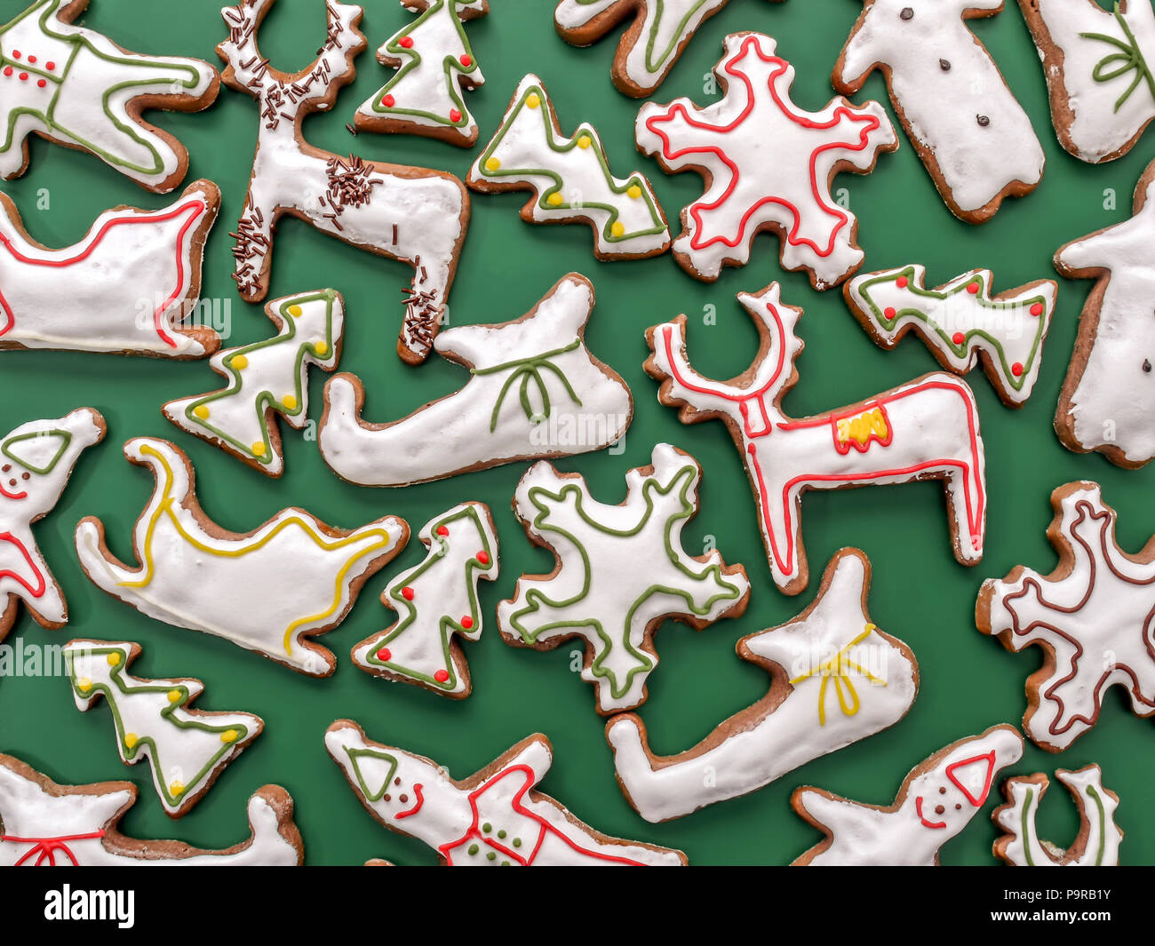 Gingerbread cookies en forme de saison avec glaçage blanc sur fond vert Banque D'Images