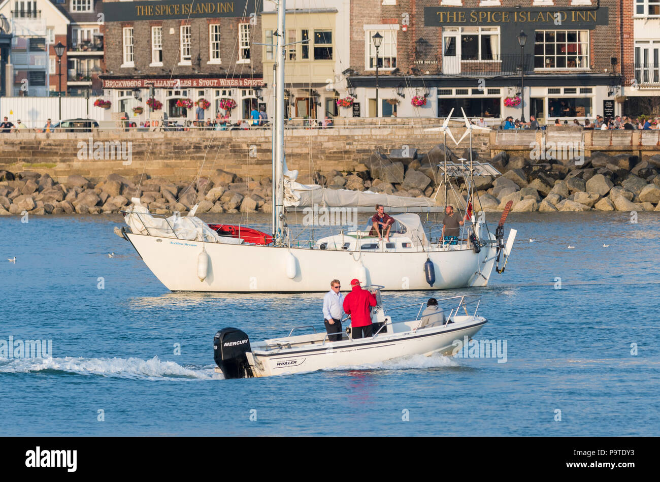 Un yacht et petit bateau sur l'eau à la fin de soir en été dans la région de Portsmouth, Hampshire, England, UK. Banque D'Images