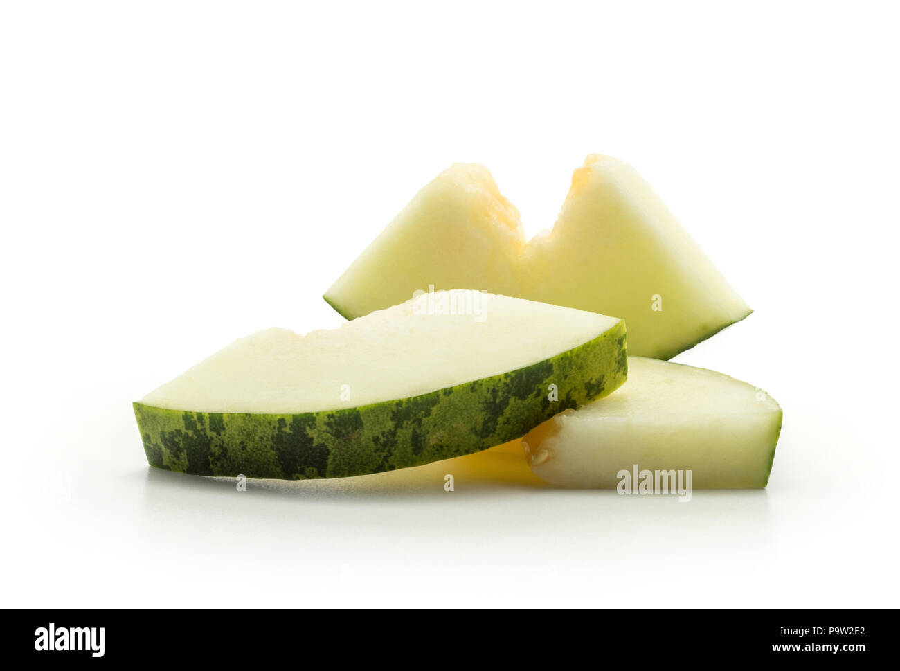 Melon Piel de Sapo trois morceaux coupés (Santa Claus Noël variété) isolé sur fond blanc sans pépins Banque D'Images
