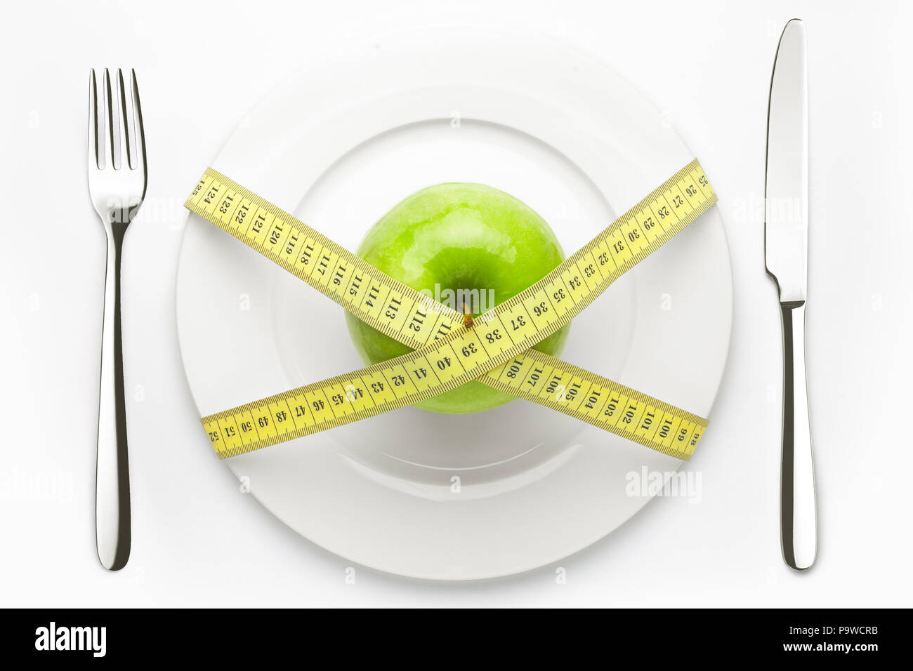Concept de régime, vert pomme sur une assiette blanche, jaune sur mesure Banque D'Images