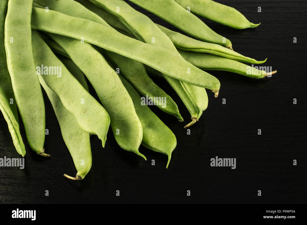 Haricots verts plat isolé sur fond de bois noir Vue de dessus Banque D'Images