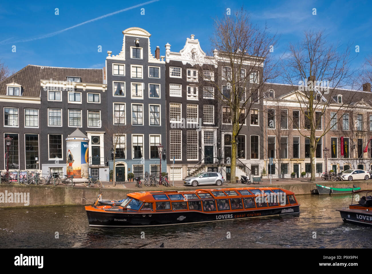 Excursions bateau sur un canal à Amsterdam, Pays-Bas, Europe avec canal traditionnelles maisons derrière Banque D'Images