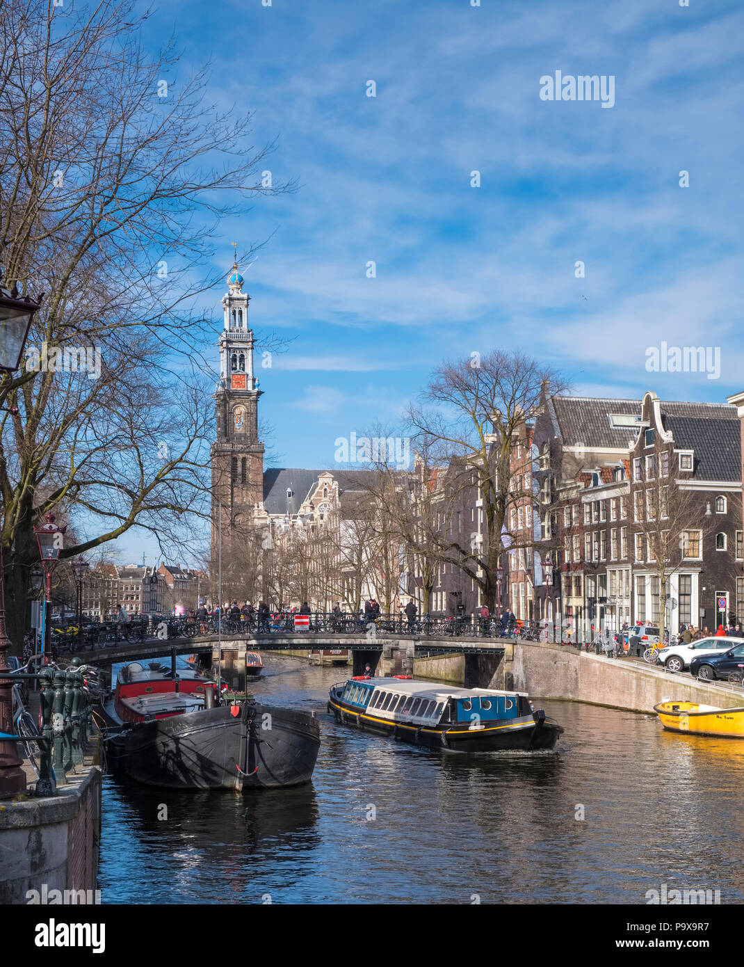 Nombreux vélos sur un pont surplombant un canal à Amsterdam, Pays-Bas, Europe avec un bateau sous voile Banque D'Images