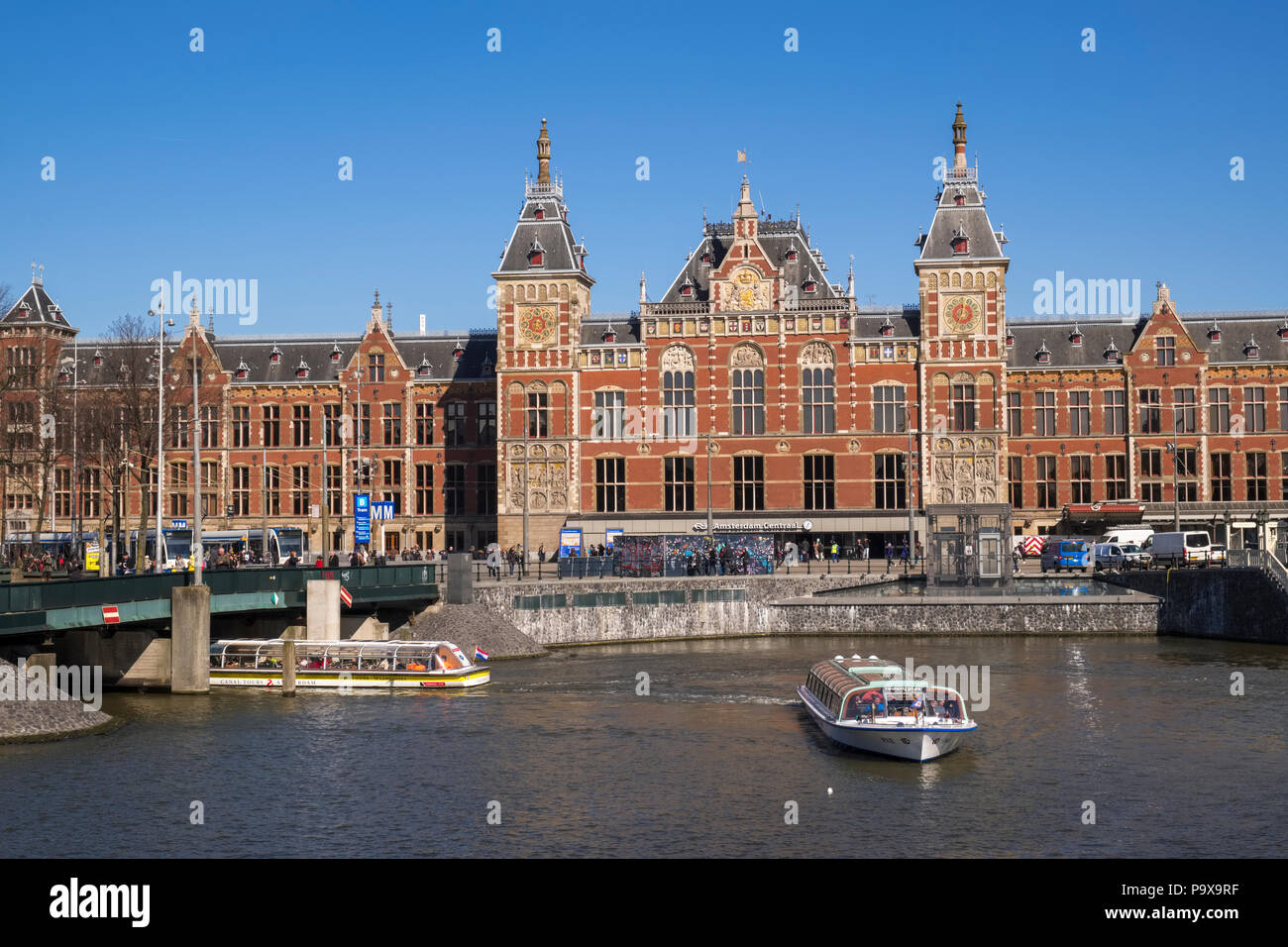 Amsterdam Centraal Station la gare centrale de la ville, pays-Bas, Hollande, Europe avec un canal et des bateaux de plaisance Banque D'Images
