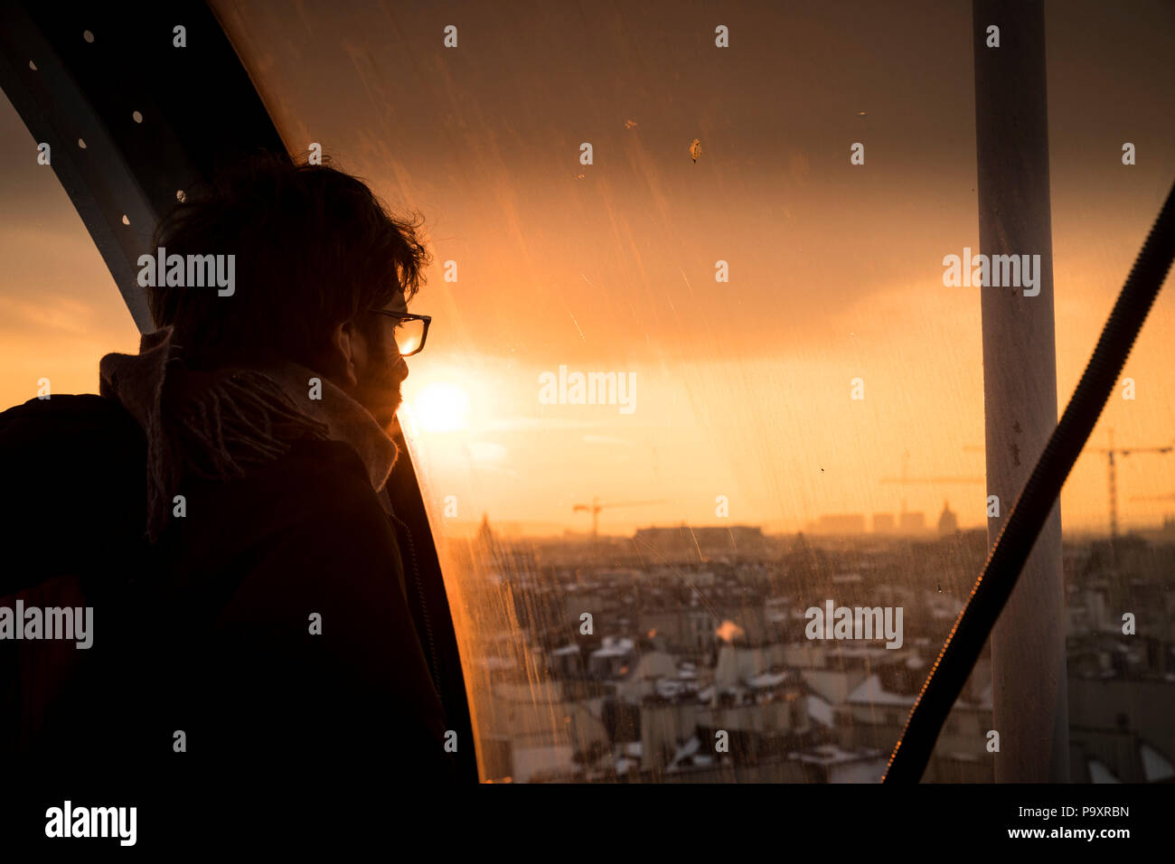 L'homme à la recherche d'une fenêtre au coucher du soleil à vue sur Paris, France au Centre Georges Pompidou Banque D'Images