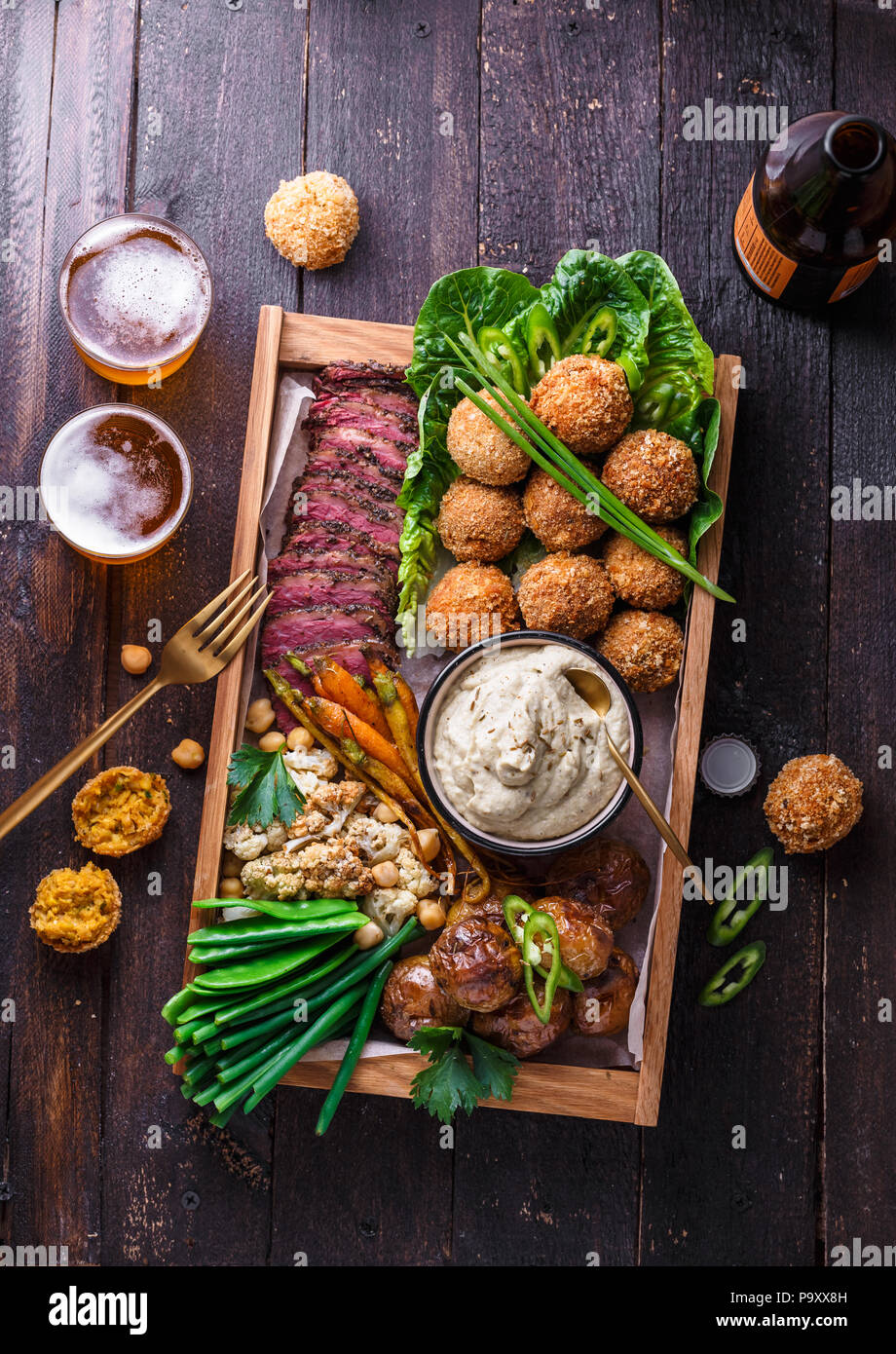 Un assortiment de plats du Moyen-Orient : falafel, viande, pomme de terre, chou-fleur et babaghanoush Banque D'Images