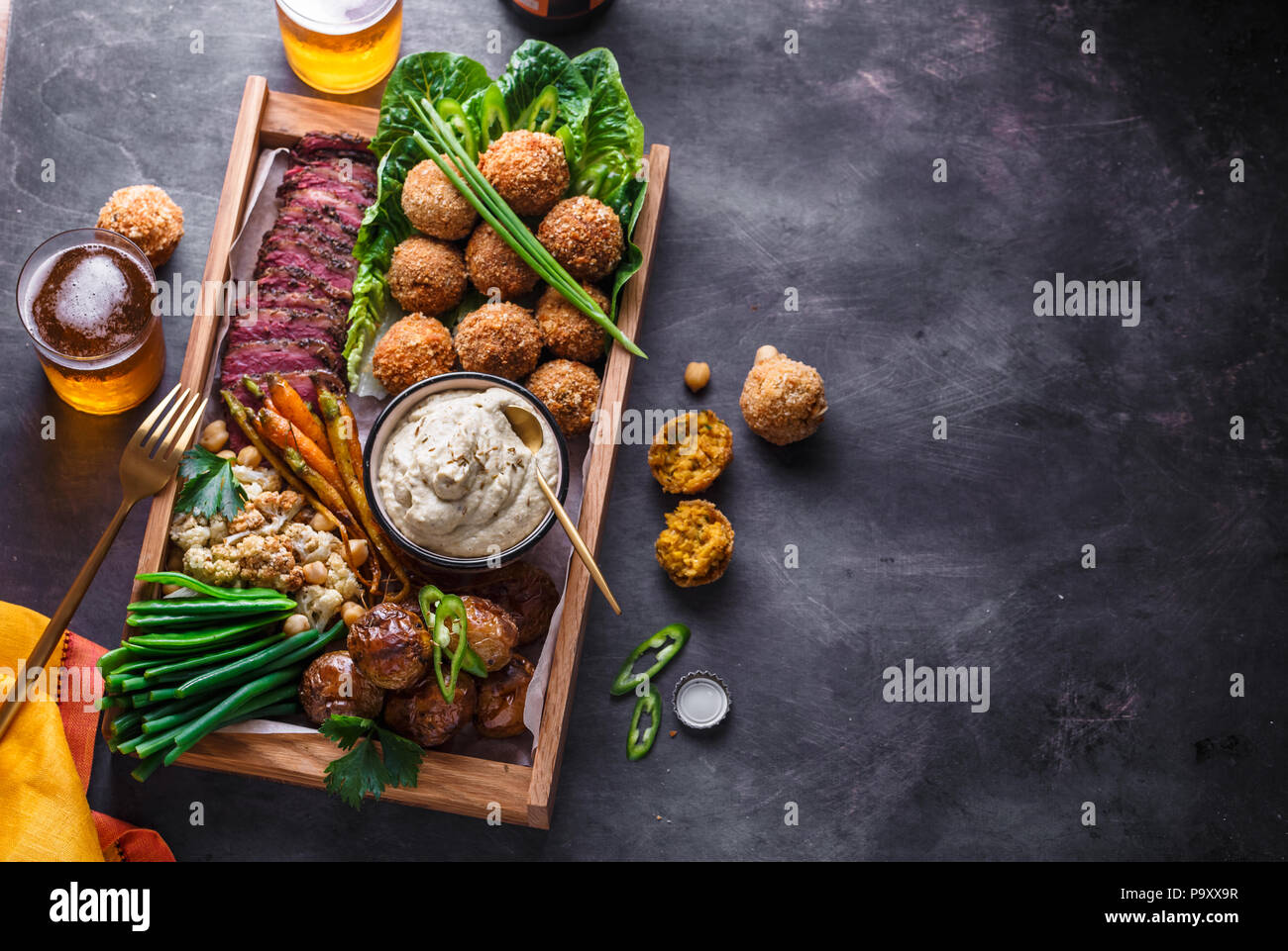 Du Moyen Orient ou des plats arabes et choix de meze sur un fond sombre. La viande, falafel, Baba Ghanoush, légumes. La nourriture halal. Copyspace. Vue d'en haut Banque D'Images