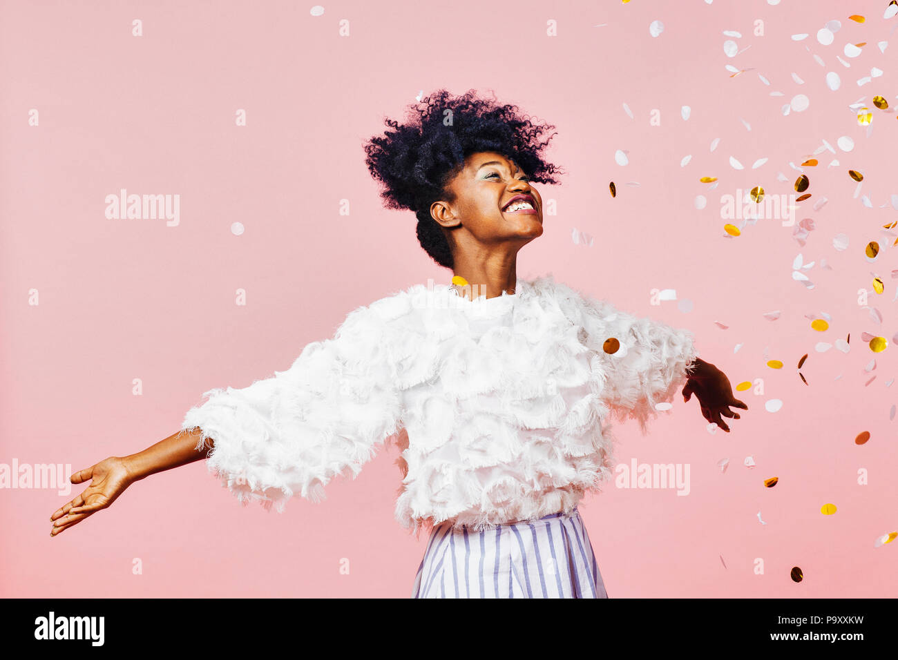 Un moment magique - Portrait d'une très bonne fille avec les bras, souriant à confettis tombant Banque D'Images