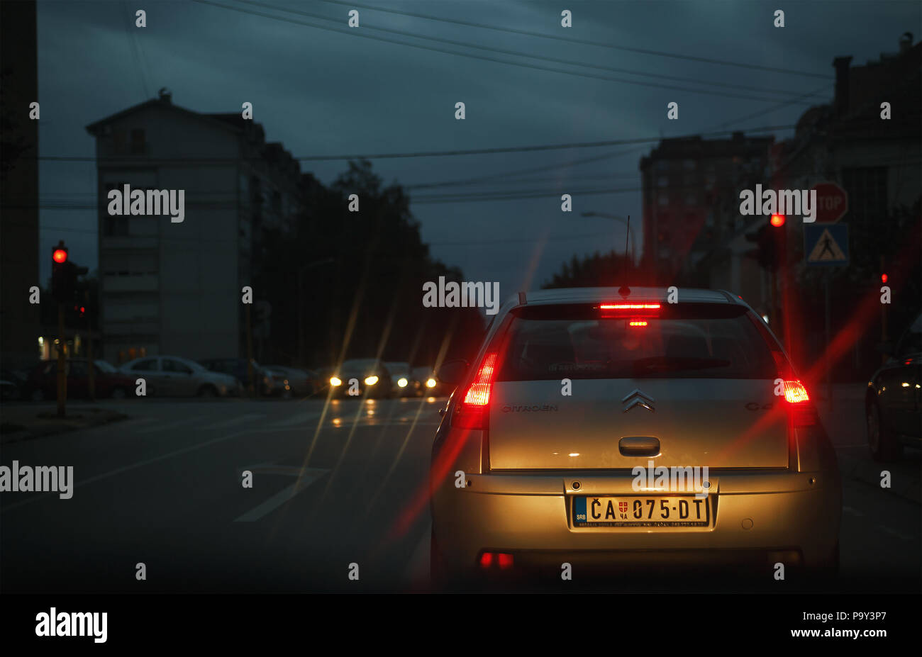 Cacak, Serbie - Juillet 19, 2018 : voyant rouge sur le sémaphore, vue de voiture sur scène en soirée à partir de la tranche dans Nemanjina street. Banque D'Images