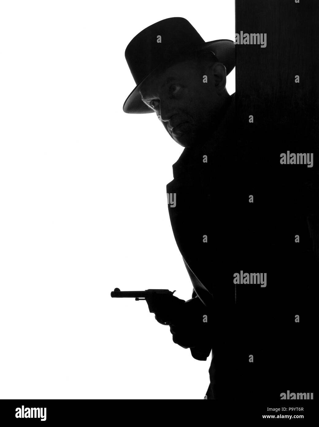 Années 1950, SILHOUETTE ANONYME D'UN HOMME PORTANT FEDORA HAT JETER AUTOUR DE COIN AVEC PISTOLET EN MAIN - c1781 HAR001 DANGER HARS COIN RISQUE HOMMES VOLEUR AGENT B&W VOLEUR COP DE PROTÉGER ET SERVIR FEDORA À MAIN ARMÉE PRIVÉE PROTECTION DANGEREUSE AVENTURE CROOK PROFESSIONS DÉTECTIVE PUISSANT GANGSTER UNIFORMES SANS VISAGE CAMBRIOLAGE MEURTRIER NOIR CHERCHEUR ÉCHAPPER CONCEPTUEL VOYOU VOYOU TIREUR OFFICIERS ANONYME POLICIERS FLICS PI MI-ARMES À FEU ARMES À FEU MI-ADULTES HOMME ADULTES MENACE MENACE PISTOLET NOIR ET BLANC BADGES BADGE FILM NOIR HAR001 old fashioned Banque D'Images
