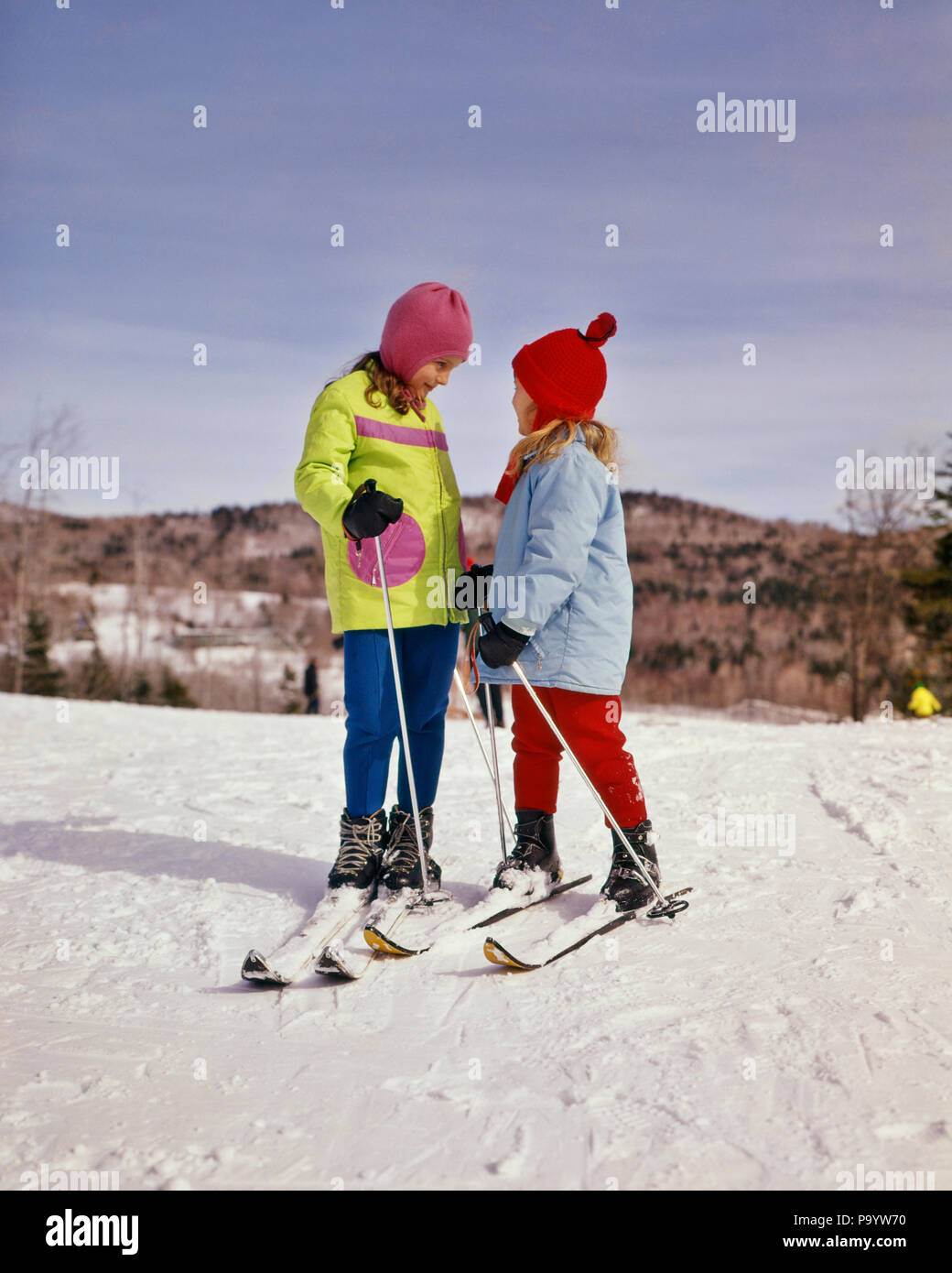 1970 2 enfants filles juvénile portant des parkas SKI PASTEL PERMANENT SŒURS PARLER - KW3194 HAR001 HARS FRÈRES SOEURS ACTIVITÉ HIVER AVENTURE BONHEUR LOISIRS LOISIRS CONNEXION FRÈRE PENTE CROISSANCE ÉLÉGANT PASTEL MINEURS PRÉ-ADO fille préadolescente unité ethnique Caucasienne HAR001 old fashioned PARKAS Banque D'Images