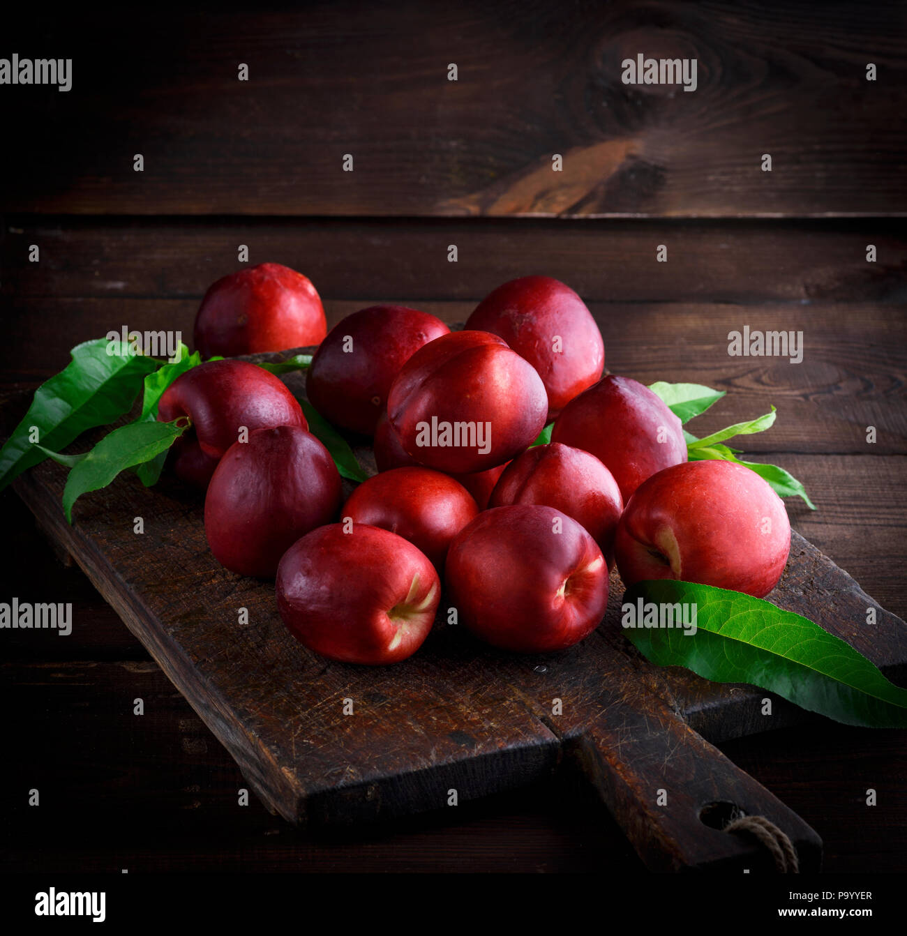 Pêches et nectarines rouges sur une planche de bois brun, copy space Banque D'Images